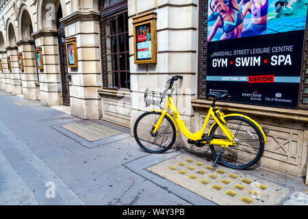 Hire Scheme jaune dockless ofo location garée dans la rue, Londres, UK Banque D'Images