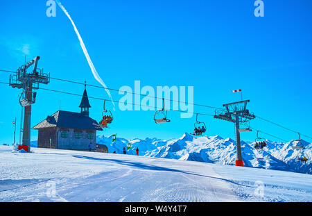 ZELL AM SEE, Autriche - 28 février 2019 : Profitez d'un paysage hivernal de Schmitten mount avec corduroy pistes de ski run, équitation, télésiège, Elisabeth chapelle Banque D'Images