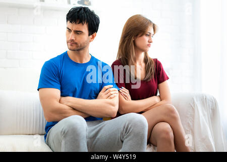 Famille couple assis sur le canapé ne parle pas après l'argumentation, jeune mari est fatigué des querelles constantes offensé femme tourna le dos à boyfri Banque D'Images