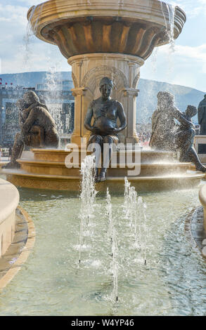 2018:SKOPJE,RÉPUBLIQUE DE MACÉDOINE-NORD 25 AOÛT 2018:statues et fontaines à la place ensuite au Musée d'archéologie et pont de pierre. Banque D'Images