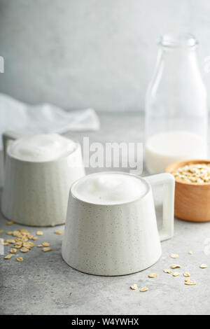 Le lait d'avoine en mousse épaisse avec latte tasses en céramique Banque D'Images