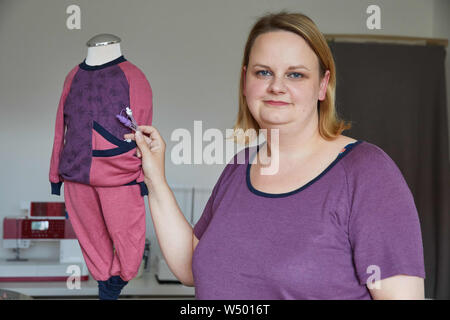 Hamburg Bergedorf, Allemagne. 07 juillet, 2019. Sandra Brunner, fondateur de la start-up 'Einzignaht', se trouve dans son studio à côté d'un chandail et pantalon avec une ouverture spéciale pour un tube stomacal. Credit : Georg Wendt/dpa/Alamy Live News Banque D'Images