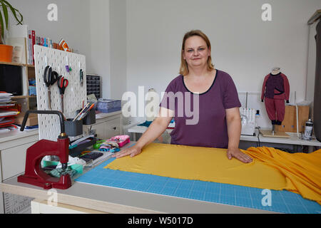 Hamburg Bergedorf, Allemagne. 07 juillet, 2019. Sandra Brunner, fondateur de la start-up 'Einzignaht', se trouve dans son studio à une table de travail avec un rouleau de tissu. Credit : Georg Wendt/dpa/Alamy Live News Banque D'Images