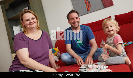 Hamburg Bergedorf, Allemagne. 07 juillet, 2019. Sandra et Christian Brunner, fondateurs de la start-up 'Einzignaht', et leur fille Laura s'asseoir sur le canapé de leur salon. Credit : Georg Wendt/dpa/Alamy Live News Banque D'Images