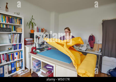 Hamburg Bergedorf, Allemagne. 07 juillet, 2019. Sandra Brunner, fondateur de la start-up 'Einzignaht', se trouve dans son studio à une table de travail avec un rouleau de tissu. L'aide au démarrage d'une couture unique produit des vêtements sur mesure pour les enfants handicapés. Credit : Georg Wendt/dpa/Alamy Live News Banque D'Images