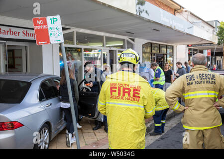 Les services d'urgence incendie, ambulancier et agent de police assister à Avalon beach scène où lady a conduit sa voiture de la chaussée et pas dans une vitrine Banque D'Images