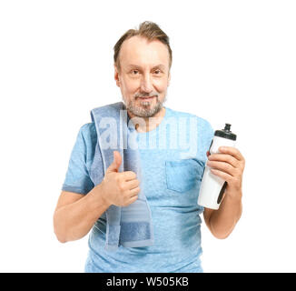 Portrait of handsome man avec une bouteille d'eau showing thumb-up geste sur fond blanc Banque D'Images