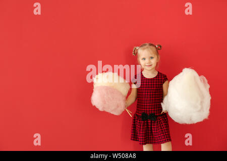 Cute little Girl with Cotton Candy sur un fond de couleur Banque D'Images