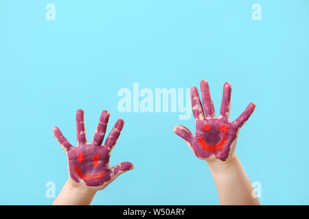 Les mains de l'enfant dans la peinture sur un fond de couleur Banque D'Images