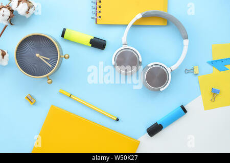 La composition avec la papeterie, réveil et d'écouteurs sur un fond de couleur Banque D'Images