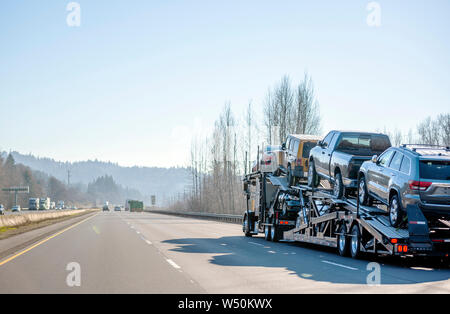 Gros camion transporteur de voitures professionnel de qualité commerciale semi truck transport de voitures sur les deux semi-remorque spéciale niveau déménagement sur la route droite wit Banque D'Images