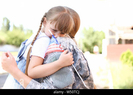 Petite fille pleurer en disant au revoir à sa mère militaire à l'extérieur Banque D'Images