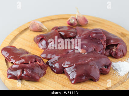 Foie de poulet sur une planche en bois sur fond blanc Banque D'Images