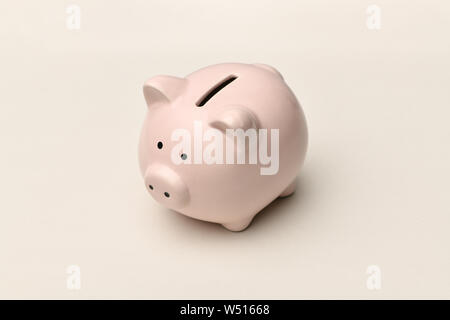 Pink Piggy Bank se dresse sur un fond gris avec une ombre. Photographie horizontale Banque D'Images