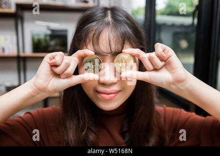 Funny man un Bitcoin Litecoin or et fermé son œil Banque D'Images