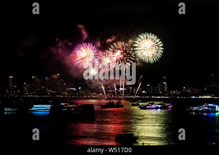 Of Fireworks par la plage et la mer entourant avec hôtels, restaurant, et les bateaux de service et des croisières pendant le temps de crépuscule bleu Banque D'Images