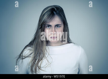 Agacé irrité jeune adolescent à la fille en colère et fou. Se sentant frustrés faisant des gestes furieux. Close up studio shot isolé sur dos neutre Banque D'Images