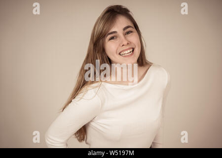 Portrait of young woman with adolescent heureux face smiling s'amusant à poser et la modélisation. Studio shot isolé avec copie espace. Dans les gens, hum Banque D'Images