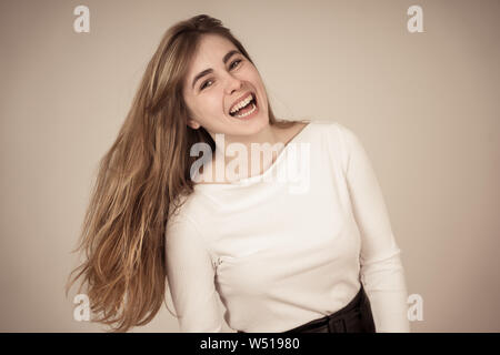 Portrait of young woman with adolescent heureux face smiling s'amusant à poser et la modélisation. Studio shot isolé avec copie espace. Dans les gens, hum Banque D'Images