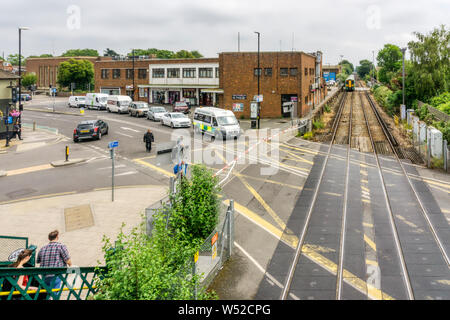 Passage à niveau fermé avec des barrières automatiques à l'extérieur de la gare de Chichester, West Sussex. Banque D'Images