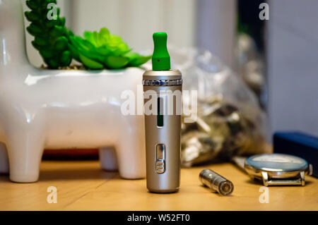 Vape stylo avec le THC CBD cartouche d'huile sur une table de jus vape à la maison. Banque D'Images