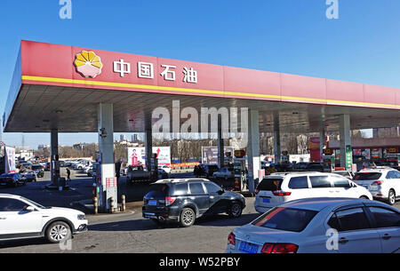 --FILE--voitures font la queue jusqu'à faire le plein à une station-service de la CNPC (China National Petroleum Corporation), la société mère de PetroChina, à Dalian city, pas de Banque D'Images