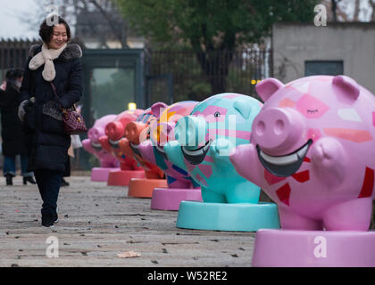 Une jeune femme chinoise marche dernières sculptures en forme de cochon à l'East Zhonghua Gate Culture historique bloc dans Shanghai, de Jiangsu est bauvin Banque D'Images