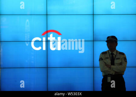 --FILE -- un membre du personnel de sécurité monte la garde à côté d'une carte électronique montrant le logo de Citi (Citigroup) à Shanghai, Chine, 13 mars 2014. Fi Banque D'Images