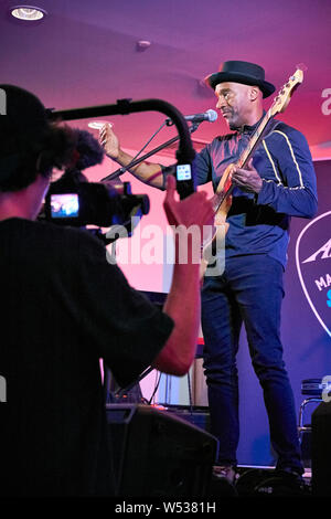 Marcus Miller semble promouvoir sa propre gamme de Sire basses à l'Harbour Hotel Guildford en partenariat avec musique Andertons. Connu sous le nom de la chèvre (plus grand de tous les temps), Marcus a joué de la basse électrique d'abord en tant que musicien de studio dans un style jazz-funk puis avec Miles Davis à partir de 2002 et a collaboré sur des albums 'Tutu', 'Amandla' et 'Siesta'. Il a aussi écrit pour Luther Vandross, Dave Sanborn, Donald Fagen. Deux fois lauréat du prix Grammy, en 2013 il a été nommé Artiste de l'UNESCO pour la paix. Il est aussi un producteur, arrangeur et compositeur. Le plus notable de ses propres albums sont 'The Sun Don't Lie' et 'Tales'. Banque D'Images