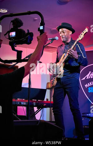 Marcus Miller semble promouvoir sa propre gamme de Sire basses à l'Harbour Hotel Guildford en partenariat avec musique Andertons. Connu sous le nom de la chèvre (plus grand de tous les temps), Marcus a joué de la basse électrique d'abord en tant que musicien de studio dans un style jazz-funk puis avec Miles Davis à partir de 2002 et a collaboré sur des albums 'Tutu', 'Amandla' et 'Siesta'. Il a aussi écrit pour Luther Vandross, Dave Sanborn, Donald Fagen. Deux fois lauréat du prix Grammy, en 2013 il a été nommé Artiste de l'UNESCO pour la paix. Il est aussi un producteur, arrangeur et compositeur. Le plus notable de ses propres albums sont 'The Sun Don't Lie' et 'Tales'. Banque D'Images