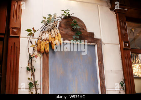 Le maïs sur planche de bois avec espace pour texte en ville rue, maison de vacances de décoration d'automne store fronts. Halloween décoration de rue. Joyeux Thanksgiving. Happ Banque D'Images