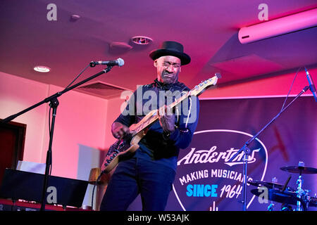 Marcus Miller semble promouvoir sa propre gamme de Sire basses à l'Harbour Hotel Guildford en partenariat avec musique Andertons. Connu sous le nom de la chèvre (plus grand de tous les temps), Marcus a joué de la basse électrique d'abord en tant que musicien de studio dans un style jazz-funk puis avec Miles Davis à partir de 2002 et a collaboré sur des albums 'Tutu', 'Amandla' et 'Siesta'. Il a aussi écrit pour Luther Vandross, Dave Sanborn, Donald Fagen. Deux fois lauréat du prix Grammy, en 2013 il a été nommé Artiste de l'UNESCO pour la paix. Il est aussi un producteur, arrangeur et compositeur. Le plus notable de ses propres albums sont 'The Sun Don't Lie' et 'Tales'. Banque D'Images