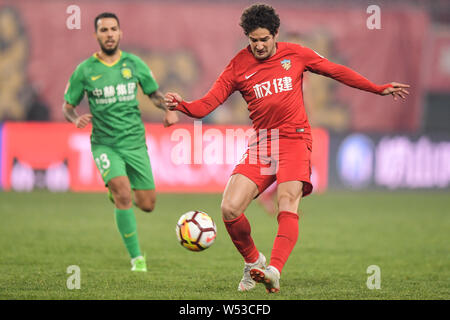--FILE, joueur de football brésilien, Alexandre Rodrigues da Silva, connu sous le nom de Pato, de Tianjin Quanjian passe le ballon contre un joueur d'Sinobo Beijing Banque D'Images