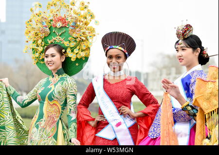 Les participants habillés en costumes traditionnels participent à une session de photos en plein air pour le 53e concours de Miss Tous Nationsl Shanghai, Chine de l'Est. Banque D'Images