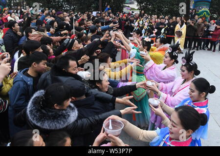 Les travailleurs chinois habillés en costumes traditionnels faire dix tonnes de Congee Laba, ou des huit trésors du porridge, pour les visiteurs dans un gigantesque pot de fer avec un diamètre Banque D'Images