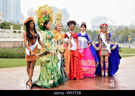 Les participants habillés en costumes traditionnels participent à une session de photos en plein air pour le 53e concours de Miss Tous Nationsl Shanghai, Chine de l'Est. Banque D'Images