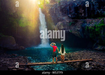 Mode de vie actif couple profiter au lever du soleil amazing waterfall Tegenungan cachés dans des forêts tropicales, Jungle Island, Bali, Indonésie Banque D'Images