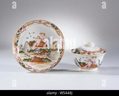 Assiette, tasse et soucoupe en forme de tasse et soucoupe couverte avec une image symbolique de Trois putti et différents objets, couvercle en forme de cloche, tasse et soucoupe en porcelaine, peintes sur l'émail en bleu, rouge, rose, vert, jaune, marron, noir et or. Sur la plaque du plat une représentation symbolique avec trois putti, l'un des qui souffle des bulles de savon dans un tuyau, pour eux un panier en osier, pyramide, skull, masque, couronne, globe, livres et autres objets, le bord d'une bande de feuilles de vignes et de deux soleils avec un visage radieux. Présentation d'après un dessin de Jacob de Wit (1695-1754), 'Allégorie de l'errance Banque D'Images