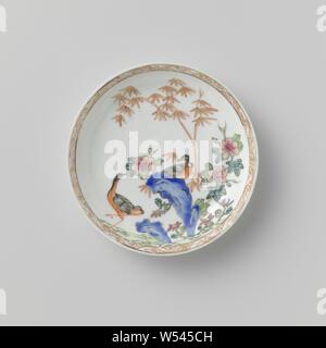 Saucer avec deux oiseaux, de roches et de plantes à fleurs, plat en porcelaine, peintes sur l'émail en bleu, rouge, rose, vert, jaune, noir et or. Deux oiseaux sur la télévision, l'un d'entre eux sur un rocher avec des plantes à fleurs (y compris la pivoine) et le bambou, le bord intérieur avec une bande étroite avec des volutes. Une fissure dans le mur. Famille rose., anonyme, la Chine, l'c. 1725 - c. 1749, dynastie Qing-(1644-1912) / Yongzheng-période (1723-1735) / période de Qianlong (1736-1795), Porcelaine, glaçure (matériel), de l'or (métal), la vitrification, H 1,9 cm d 6,7 cm 11,5 cm d Banque D'Images