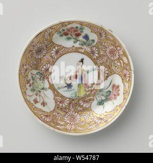 Soucoupe d'une dame avec panier de fleurs et de plantes à fleurs dans les panneaux, plat en porcelaine avec diffusion, mur peint sur l'émail en bleu, rouge, rose, vert, noir et or. Sur la plaque du plat un médaillon avec une dame dans un paysage avec un panier de fleurs, de fleurs de vignes qui ont été enregistrés dans le médaillon et trois cartouches avec des plantes à fleurs (y compris lotus) dans la masse d'or. Plat a été brisée. Famille rose., anonyme, la Chine, l'c. 1725 - c. 1749, dynastie Qing-(1644-1912) / Yongzheng-période (1723-1735) / période de Qianlong (1736-1795), Porcelaine, glaçure (matériel), de l'or (métal Banque D'Images