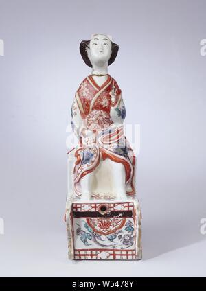 Esprit fût dans la forme d'une femme japonaise dans un char, Porcelaine, peint en jar gin bleu sous glaçure et sur l'émail rouge, vert, noir et or. La verseuse est en la forme d'une femme en kimono, assis sur un chariot avec deux roues. Son kimono est légèrement relevé, de sorte que ses jambes sont visibles. Un trou a été fait devant le panier pour le robinet. La tête est détachée du corps et agit comme un bouchon. Les roues sur le modèle des deux côtés du chariot. Le kimono est décorée avec des boissons, Clematis fleurs de cerisier et Paulowna branches. Sur l'avant du panier une boîte rectangulaire avec une couverture nuageuse et un Banque D'Images