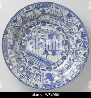 Soucoupe, lave avec chiffres chinois et de fleurs stylisées en panneaux, plat en porcelaine, décor peint en bleu. Sur la télévision dans un médaillon double une représentation d'une réunion d'un gentleman, guerrier et serviteur avec une femme chinoise, flottant sur un nuage. Les trois hommes sont debout sur une terrasse clôturé par l'eau. Avec une bande morte autour du médaillon. Le mur et frontière sont divisé en compartiments avec différents hommes dans un paysage parsemé de motifs tulipes stylisées. L'arrière avec une boîte de décoration. Dans les grandes orientations des cartouches avec compartiments morte, dans un étroit entre Banque D'Images