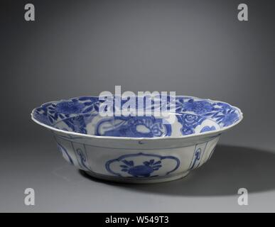 Klapmuts bol de métaux précieux et d'objets symboliques et de sprays de fleurs, Klapmuts Bol en porcelaine avec un bord cannelé, peint en bleu sous glaçure. Sur le fond une collection d'antiquités (faire défiler, la feuille de palmier, vase) et d'arcs avec glands, le mur avec quatre cartouches festonné avec lucky des objets, entre les cartouches un ruyi motif, la bordure intérieure à la fleur de vigne, le bord extérieur avec deux fois un oiseau sur une plante, la paroi extérieure avec quatre cartouches festonné avec une peach ou fleur branche alternant avec des compartiments rectangulaires avec un sceptre ruyi. Le crack en bleu et blanc porcelaine Banque D'Images