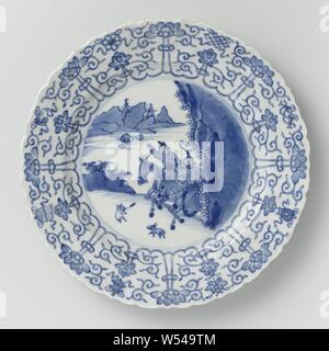 Saucer dish avec scène de chasse, lotus morte et les symboles auspicieux, plat en porcelaine avec paroi côtelée, rond et bord cannelé, peint en bleu sous glaçure. Sur la télévision d'une scène de chasse avec deux cavaliers armés dans un paysage, la chasse un lièvre, la frontière avec une bande de vrilles lotus concaténés, entre lesquels les huit symboles de bonheur (chakra, shell, parasol, auvent, lotus, vase, poisson, nœud infini), l'arrière avec 16 sprays de fleurs distinctes. Marqué sur le dessous avec la marque à six caractères de l'empereur dans un double cercle Xinian Square. Edge légèrement endommagé. Bleu Blanc., anonyme, de la Chine, c Banque D'Images