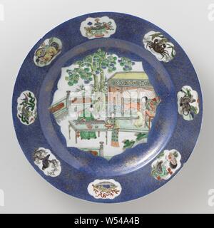 Lave, lave avec bleu poudre et des figures sur une terrasse, plat en porcelaine avec mur et biseau, décorées de bleu sous glaçure et sur l'émail bleu, rouge, vert, jaune, aubergine, noir et or. L'avant du plat est recouvert de poudre bleu poudré (bleu) avec un grand terrain, sculpté rempli avec trois personnes sur une terrasse avec des rochers et des deux arbres, un érudit à une table jouant sur un qin, une dame assise à une table en face d'un lit, une femme de chambre avec un bol sur un plateau, le mur avec une décoration d'or sur le bleu avec des rosettes de fleurs et de vrilles, la frontière avec une décoration d'or sur le bleu Banque D'Images