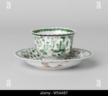 Tasse et soucoupe avec des poissons entre usines d'eau, tasse et soucoupe en porcelaine avec paroi côtelée et bord lobé, peint en bleu sous glaçure et sur l'émail bleu, rouge, vert, jaune, l'aubergine, l'or noir. L'extérieur de la tête avec quatre poissons entre les plantes aquatiques, le bord d'une bande de ruyi motif, sur le fond et d'un poisson à l'intérieur à l'aide de quatre poissons dans le fer rouge, le bord d'une bande ruyi motif. La télévision du plat avec un plus gros poissons entre les plantes aquatiques, d'autres la même décoration que sur la tête. Les deux marqué sur le dessous avec 'Yù', jade, dans un double cercle. Deux fissures dans le mur de Banque D'Images