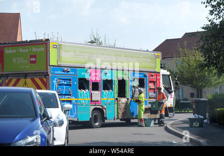 Une autorité locale recycler camion arrêté dans une rue de banlieue. Collecter les travailleurs propriétaires de déchets recyclés et la trier en catégorie différente. Banque D'Images