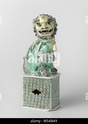 La figure d'un shishi, tasses d'image sur une base rectangulaire, haut, peint sur le biscuit avec du bleu, vert, jaune, Aubergine et noir. Sur le piédestal d'un shishi (chien) avec un lion cub. Le socle est recouvert de nappes et de travail ouvert sur deux côtés, sous la forme d'un cartouche festonné et une direction générale de la pêche. Email sur biscuit en famille verte., anonyme, la Chine, l'c. 1700 - c. 1724, Qing Dynasty, Kangxi (1644-1912) / (1662-1722) période, porcelaine (matériau), peinture, h 38,3 cm l 14,4 cm × w 11 cm Banque D'Images