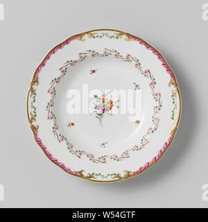 Modèle de plaque, profonde, appartenant à un service avec motif ruban tout enguirlandés avec feuilles, bouquets de fleurs éparpillés et branches, appartenant à un service en porcelaine avec motif ruban tout enguirlandés de pourpre et d'or avec des feuilles vertes, bouquets de fleurs éparpillés et branches. Les bords légèrement le carton ondulé à décor en or avec un motif de feuilles pourpre vert feuille croisés entre lesquels le motif. Marqué : Mf. L'DIHL ET GUERHARD à PARIS. Série de onze pièces., Dihl et Guerhard, Amsterdam, 1780 - en 1820 ou avant, porcelaine (matériau), h 4 cm × d 24,5 cm Banque D'Images