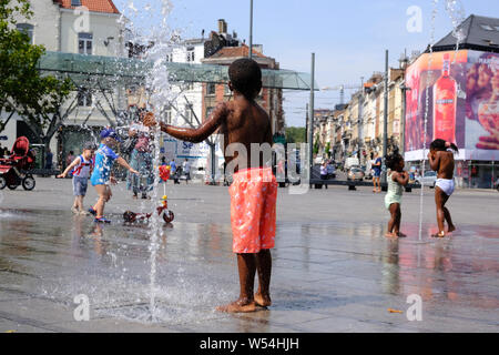 Bruxelles, Belgique. 26 juillet 2019. Les gens se rafraîchir dans l'eau des fontaines de la Place Flagey. Credit : ALEXANDROS MICHAILIDIS/Alamy Live News Banque D'Images